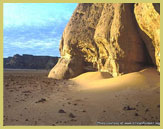 Sahara desert sands pile against a sandstone outcrop in Tassili N'Ajjer world heritage site (Algeria)