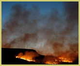 Grass fire at dusk - hinting at a violent past at the world’s largest and oldest meteorite impact event at Vredefort Dome world heritage site, South Africa