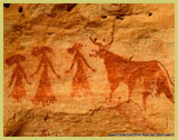 The Ennedi Massif (Chad) has an extraordinary wealth of rock art, this particular panel - probably less than 3000 years old - features three women in dresses and elaborate hats standing to the left of a cow