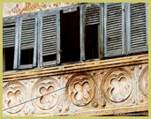 Decaying window shutters and decorative detail on one of the prominent French colonial buildings in the historic town of Grand-Bassam UNESCO world heritage site (Cote d'Ivoire)
