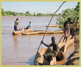 Local people using dugout canoes to cross the Omo River close to the Lower Valley of the Omo UNESCO world heritage site (Ethiopia)